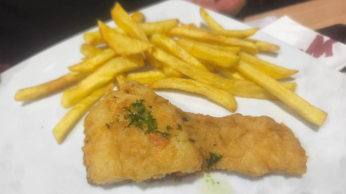 Plato de bacalao frito acompañado de patatas fritas servido en Bar La Nevera
