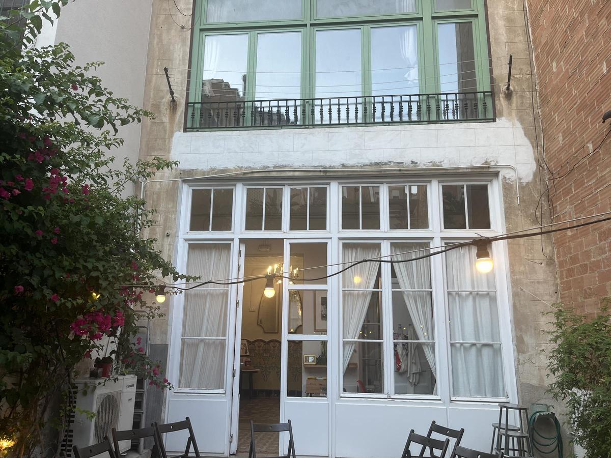 Patio trasero de Casa Usher en Barcelona, con baldosas hidráulicas, mosaicos mediterráneos y buganvilla lila