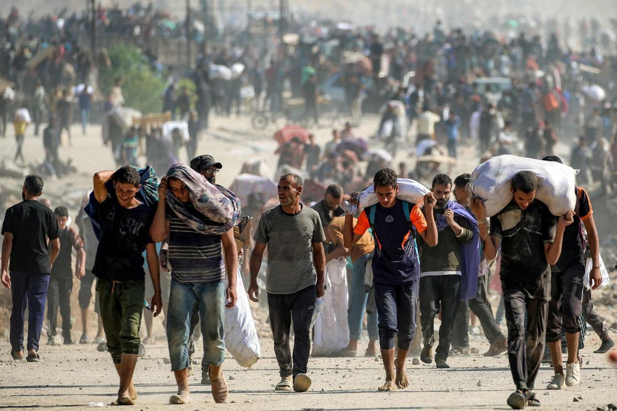 Gazatíes cargando ayuda distribuida por la Fundación Humanitaria de Gaza en Nuseirat, centro de la Franja