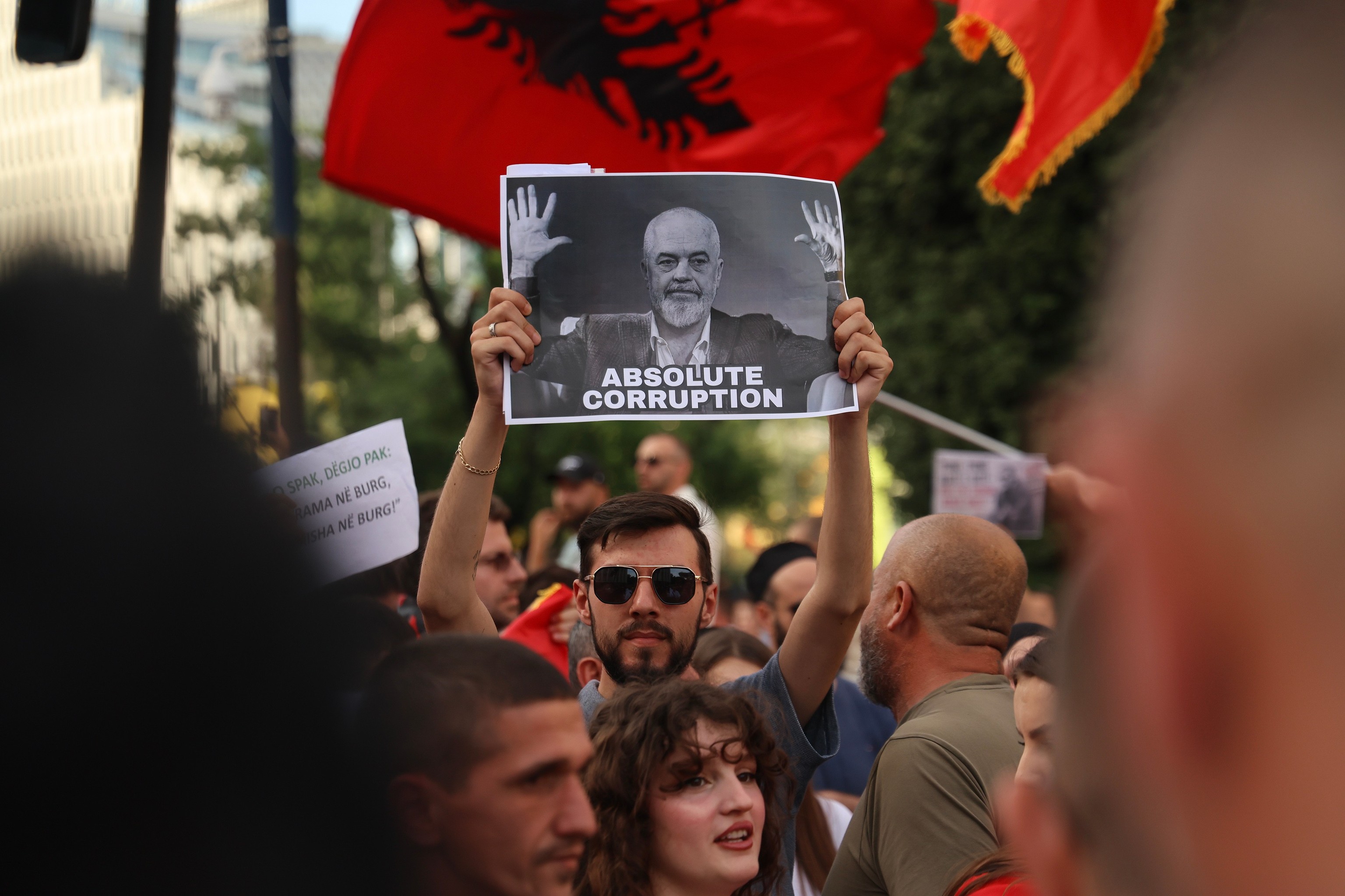 Manifestantes con carteles de flamencos frente al Parlamento de Tirana durante las protestas contra los megaproyectos de lujo