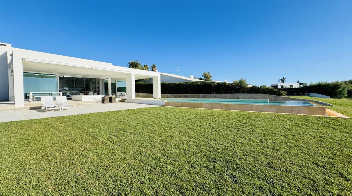 Vista frontal de la Villa Marella en Menorca con fachada blanca y ventanales al mar